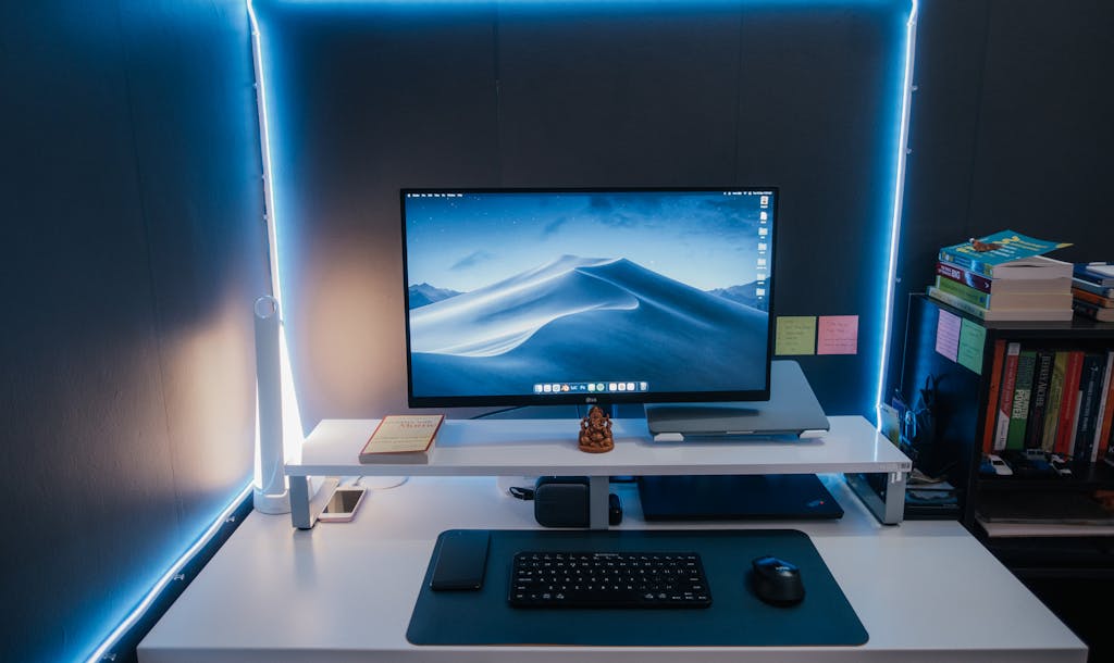 A modern and organized workspace setup with illuminated LED lighting and a desktop monitor.